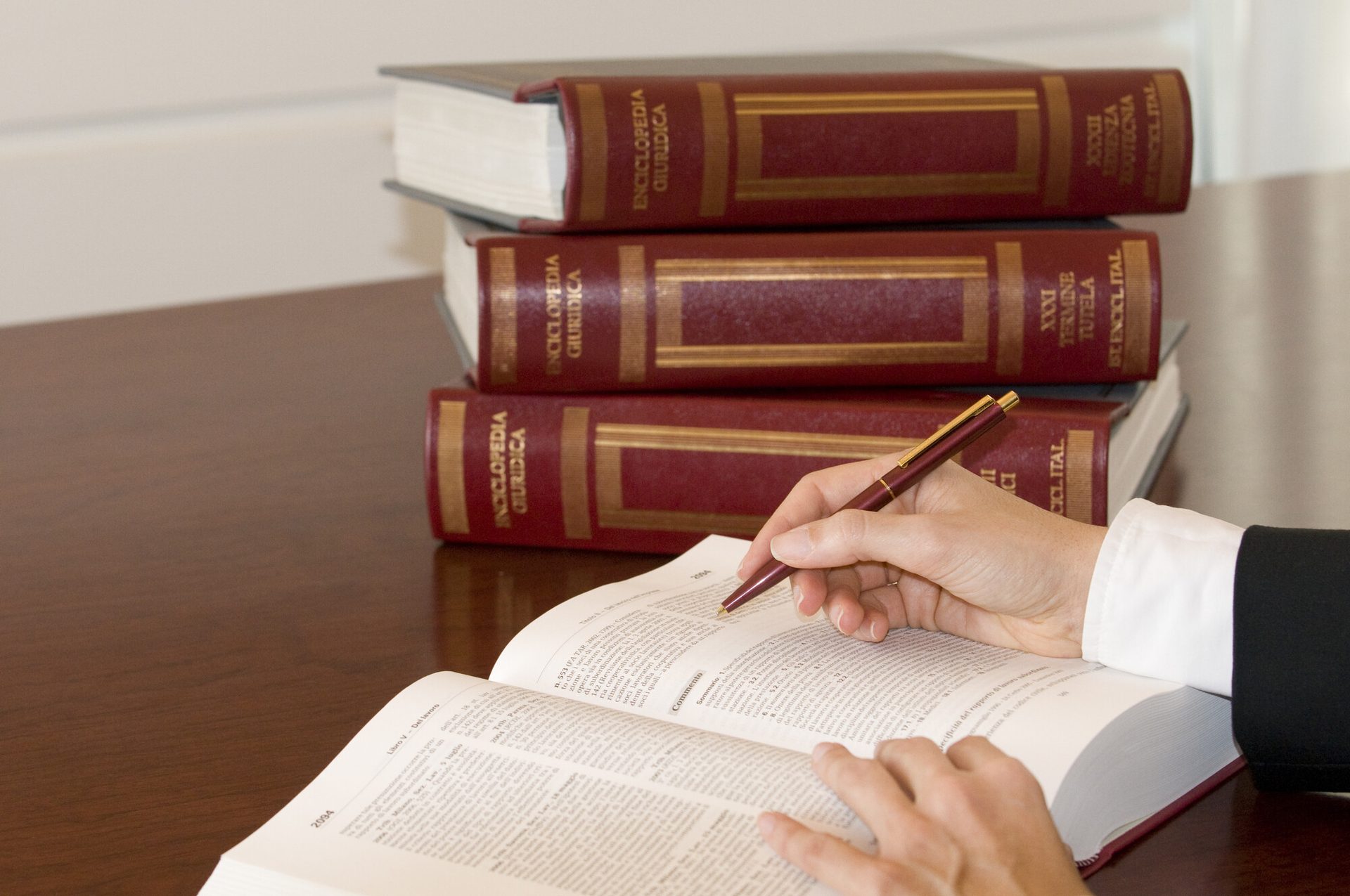 Consultazione di un'enciclopedia giuridica durante la preparazione di un atto
